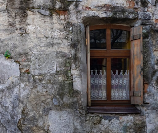 A dark wood window in a stone wall.